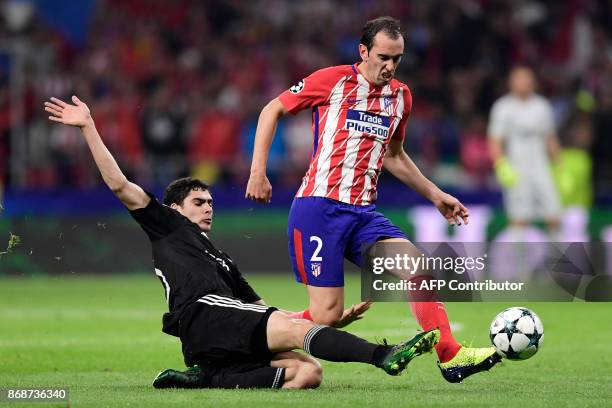 Qarabag's Azerbaijani forward Ramil Sheydaev tackles Atletico Madrid's Uruguayan defender Diego Godin during the UEFA Champions League football match...