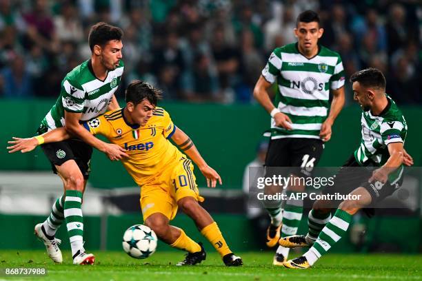 Sporting's defender Andre Pinto and Sporting's midfielder Bruno Fernandes fight for the ball with Juventus' Argentinian forward Paulo Dybala during...