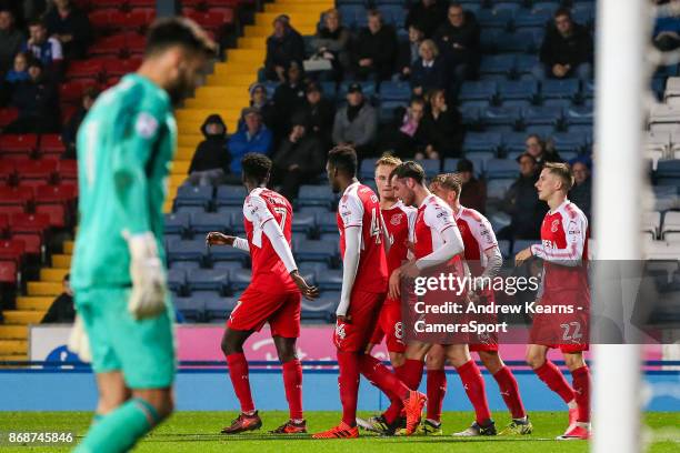 Fleetwood Town's Aiden O'Neill celebrates scoring his side's first goal with his team mates as Blackburn Rovers' goalkeeper David Raya walks back to...