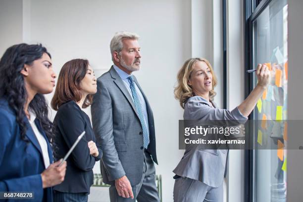 business team discussing ideas to write on notes at office - formalwear stock pictures, royalty-free photos & images