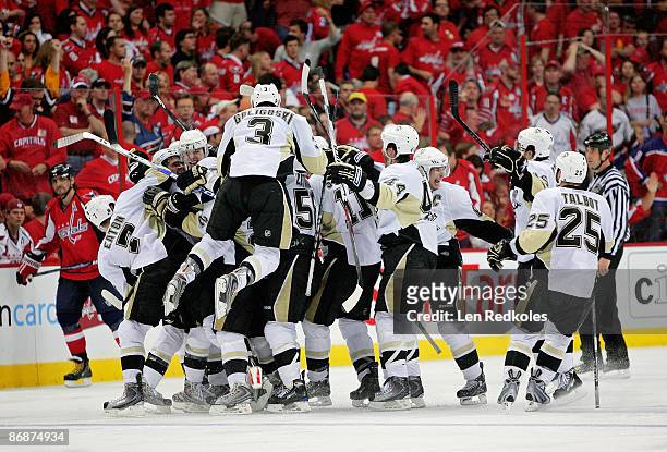 Evgeni Malkin of the Pittsburgh Penguins is mobbed by his teammates as they all celebrate Malkin's overtime winning goal over the Washington Capitals...