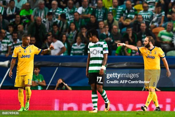 Juventus' Argentinian forward Gonzalo Higuain celebrates a goal with teammate Juventus' Brazilian midfielder Douglas Costa during the UEFA Champions...