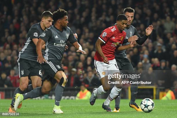 Manchester United's English striker Marcus Rashford is fouled in the penalty area by Benfica's Greek midfielder Andreas Samaris leading to a penalty...