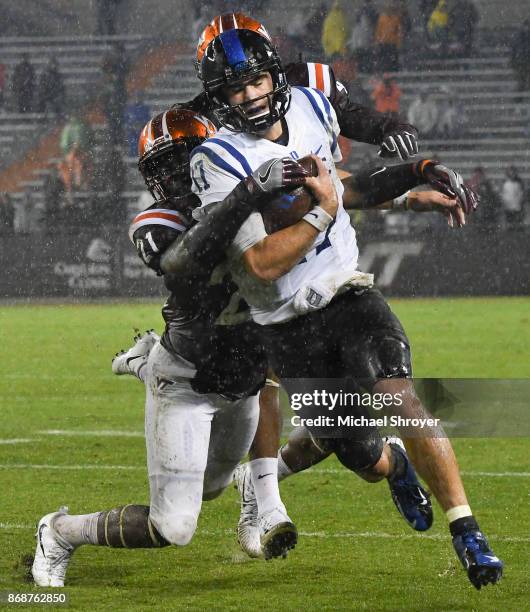 Quarterback Daniel Jones of the Duke Blue Devils is hit from behind by safety Reggie Floyd of the Virginia Tech Hokies in the second half at Lane...