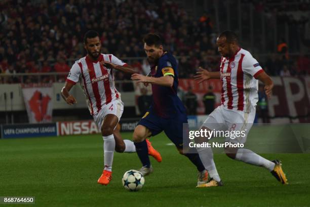 Lionel Messi of Barcelona vies for the ball with Olympiakos' Belgian midfielder Vadis Odjida and Olympiakos' French-Togolese midfielder Alaixys Romao...