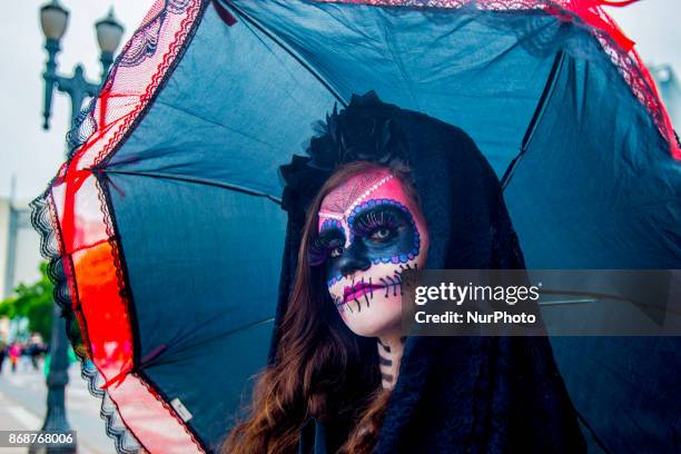 Woman wearing Mexican skull costume and makeup is seen at the Santa Ifigênia Viaduct in São Paulo on 31 October 2017, the day that is celebrated on...