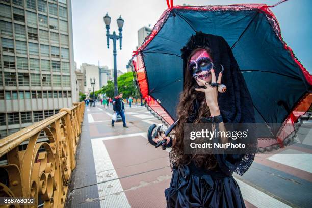 Woman wearing Mexican skull costume and makeup is seen at the Santa Ifigênia Viaduct in São Paulo on 31 October 2017, the day that is celebrated on...