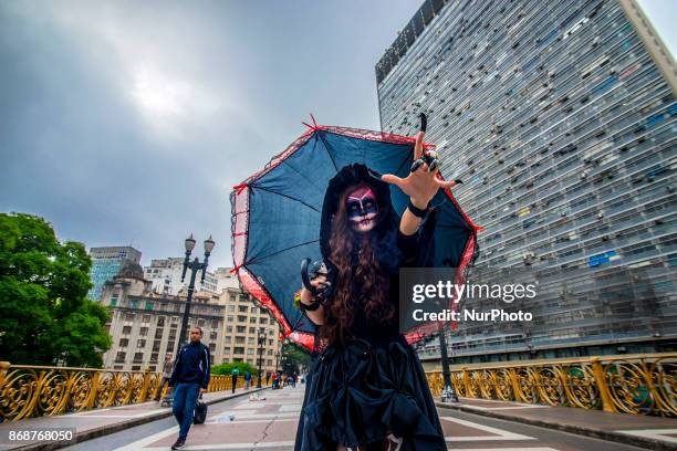 Woman wearing Mexican skull costume and makeup is seen at the Santa Ifigênia Viaduct in São Paulo on 31 October 2017, the day that is celebrated on...