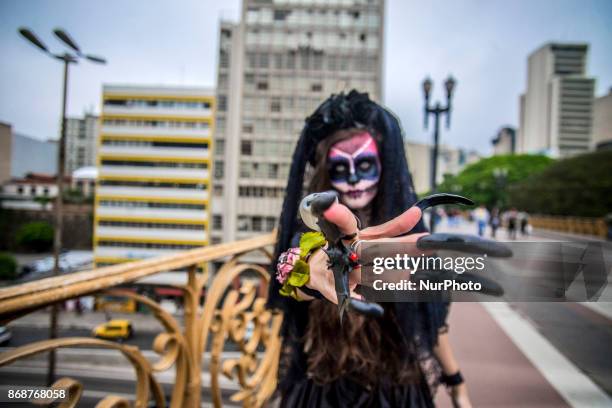 Woman wearing Mexican skull costume and makeup is seen at the Santa Ifigênia Viaduct in São Paulo on 31 October 2017, the day that is celebrated on...