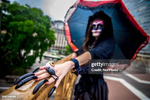 Woman wearing Mexican skull costume and makeup is seen at the Santa Ifigênia Viaduct in São Paulo on 31 October 2017, the day that is celebrated on...