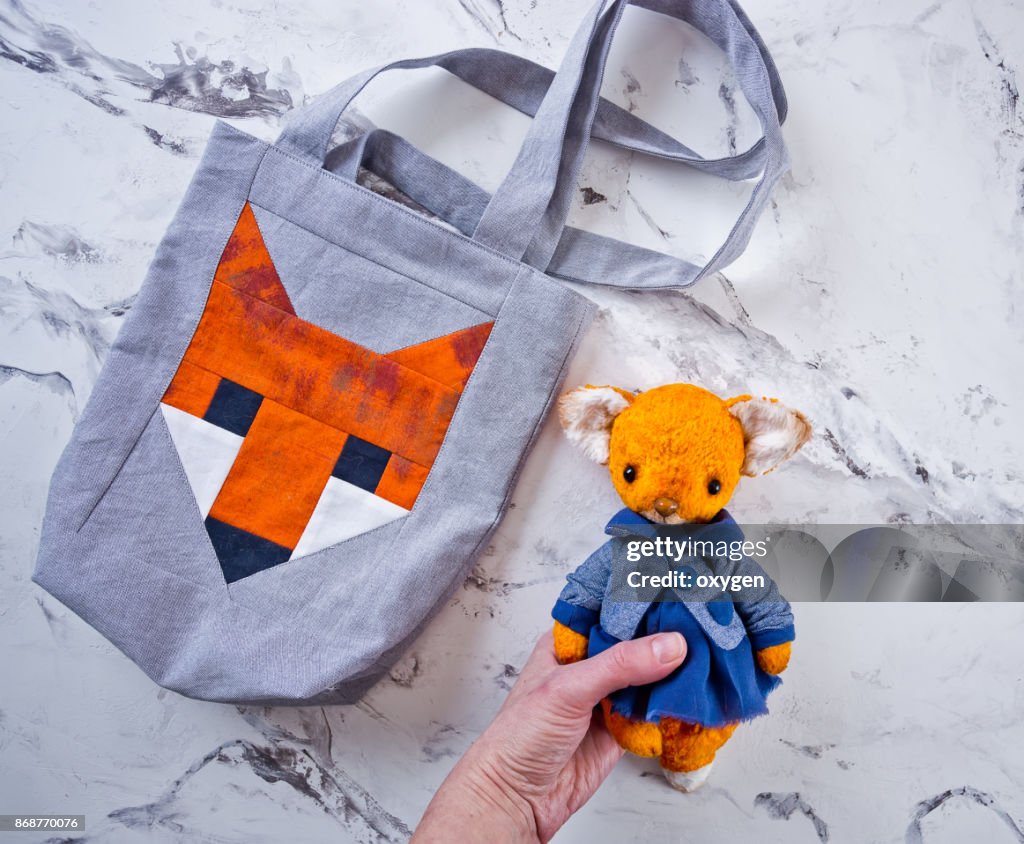 Female holding toy fox on marble gray table