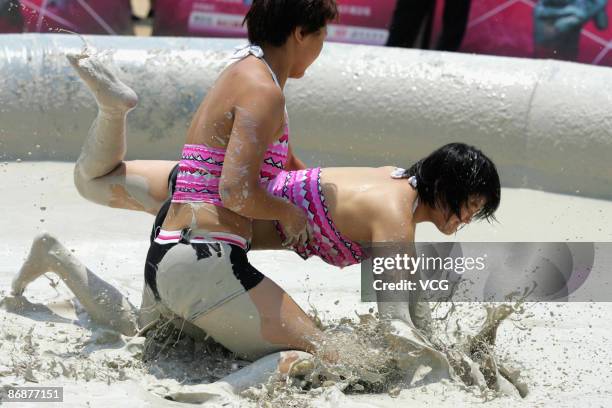 Participants compete during the final of the international women's mud wrestling contest along the East Lake on May 10, 2009 in Wuhan of Hubei...