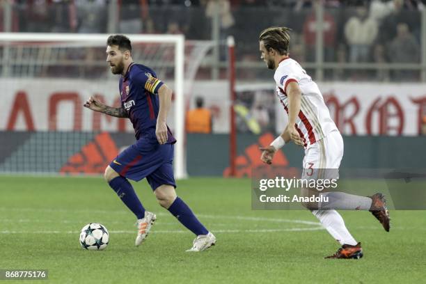 Lionel Messi of Barcelona in action against Guillaume Gillet of Olympiakos during a UEFA Champions League match between Olympiakos and Barcelona at...