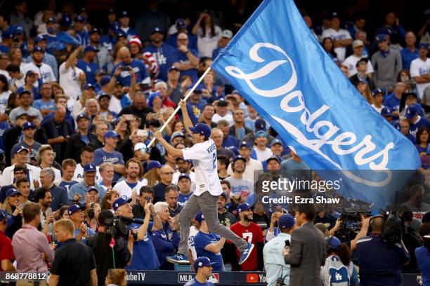 Actor Ashton Kutcher waves a Los Angeles Dodgers flag before game six of the 2017 World Series between the Houston Astros and the Los Angeles Dodgers...