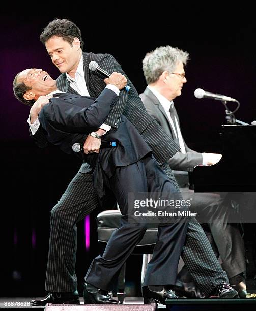 Singers Paul Anka and Donny Osmond sing the song "Puppy Love" together for the first time onstage as producer/composer David Foster performs during...