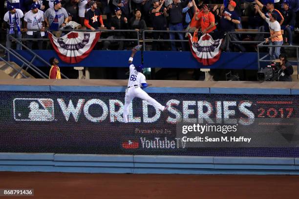 Yasiel Puig of the Los Angeles Dodgers is unable to catch a solo home run ball hit by George Springer of the Houston Astros during the third inning...