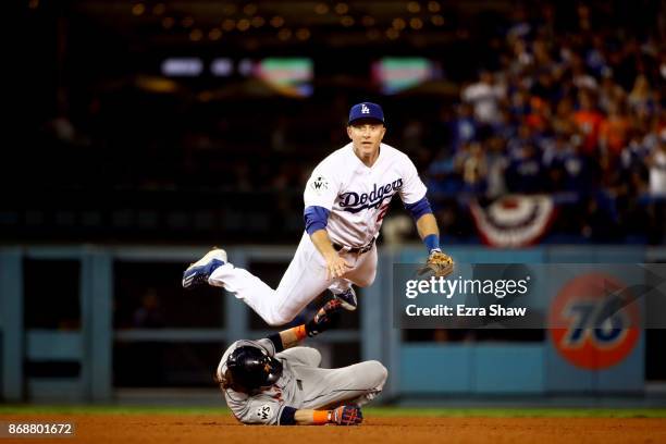 Josh Reddick of the Houston Astros is forced out at second base as Chase Utley of the Los Angeles Dodgers throws to first base during the seventh...