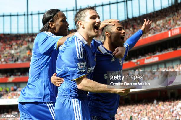Ashley Cole of Chelsea is congratulated by team mates Frank Lampard and Didier Drogba after his shot was deflected in by Kolo Toure of Arsenal for...
