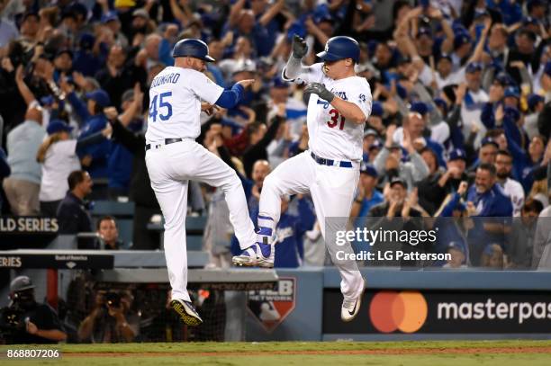 Joc Pederson of the Los Angeles Dodgers celebrates with third base coach Chris Woodward after hitting a solo home run in the seventh inning during...