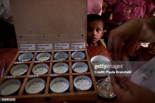 Rohingya boy watches as malaria medicine is given out to patients at special clinic for malaria on May 4, 2009 in Sittwe, Arakan state, Myanmar . The...