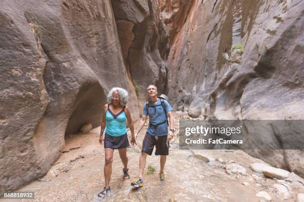 ethnic senior couple explore a slot canyon - fun lovers unite stock pictures, royalty-free photos & images