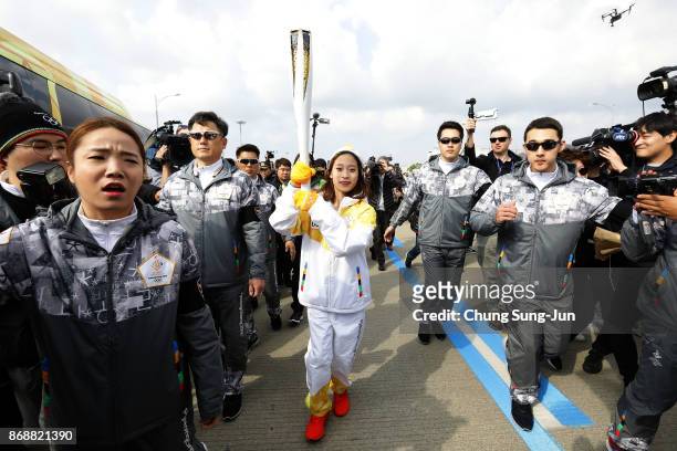 First torch bearer, South Korean figure skater You Young runs as she hold the PyeongChang 2018 Winter Olympics torch during a torch relay on November...