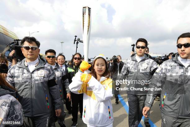 First torch bearer, South Korean figure skater You Young runs as she hold the PyeongChang 2018 Winter Olympics torch during a torch relay on November...