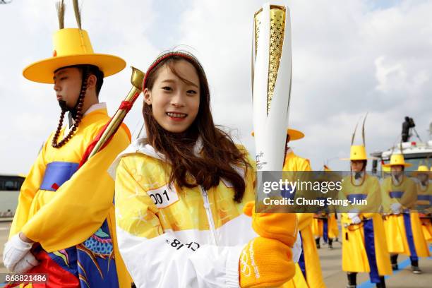 First torch bearer, South Korean figure skater You Young holds the PyeongChang 2018 Winter Olympics torch during a torch relay on November 1, 2017 in...