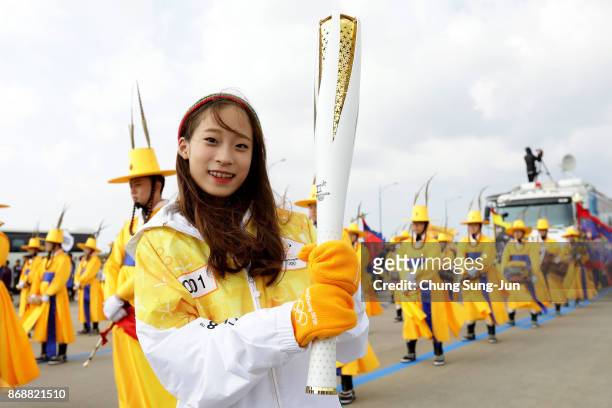 First torch bearer, South Korean figure skater You Young holds the PyeongChang 2018 Winter Olympics torch during a torch relay on November 1, 2017 in...