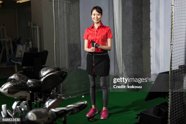 a woman with a smile at a golf studio. - glove virtual reality stock pictures, royalty-free photos & images