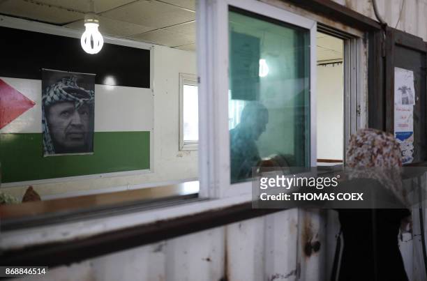 Portrait of late Palestinian leader Yasser Arafat above his national flag adorns a passport control station held by the Palestinian Authority at the...