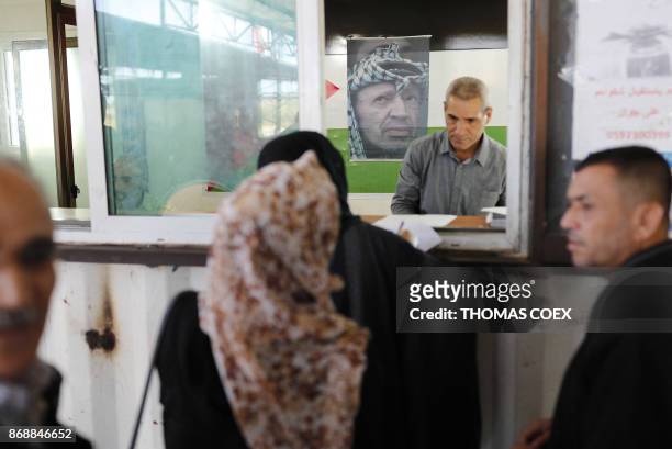 Portrait of late Palestinian leader Yasser Arafat above his national flag adorns a passport control station held by the Palestinian Authority at the...