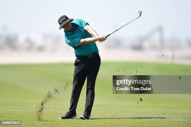 Ryan Evans of England hits an approach shot on the 9th hole during day one of the NBO Golf Classic Grand Final at Al Mouj Golf on November 1, 2017 in...