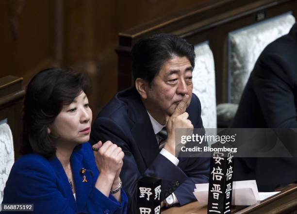 Shinzo Abe, Japan's prime minister, center, and, Seiko Noda, Japan's internal affairs and communications minister, left, attend a plenary session at...