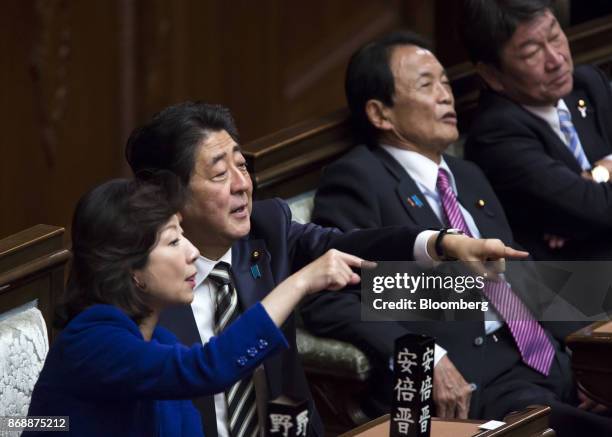 Shinzo Abe, Japan's prime minister, second left, and Seiko Noda, Japan's internal affairs and communications minister, left, gesture during a plenary...