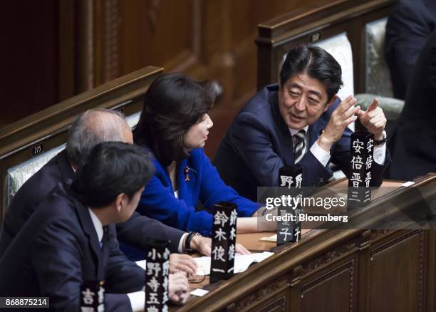 Shinzo Abe, Japan's prime minister, right, speaks with Seiko Noda, Japan's internal affairs and communications minister, center, during a plenary...