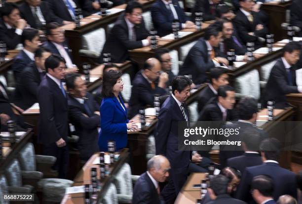 Shinzo Abe, Japan's prime minister, center right, and, Seiko Noda, Japan's internal affairs and communications minister, center left, make their way...
