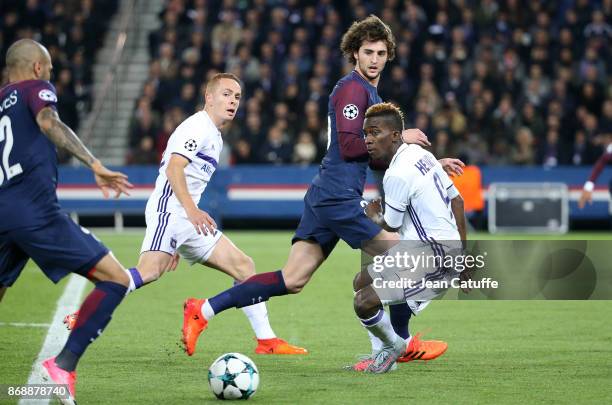 Adrien Rabiot of PSG between Adrien Trebel and Henry Onyekuru of Anderlecht during the UEFA Champions League group B match between Paris...