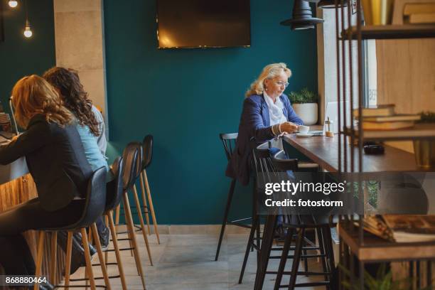 morning rituals - senior women cafe stock pictures, royalty-free photos & images