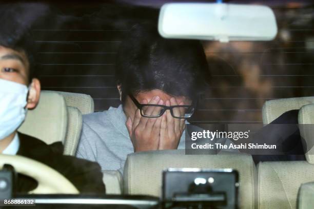 Suspect Takahiro Shiraishi covering his face is seen on departure at Takao Police Station as he is transferred to prosecutors on November 1, 2017 in...