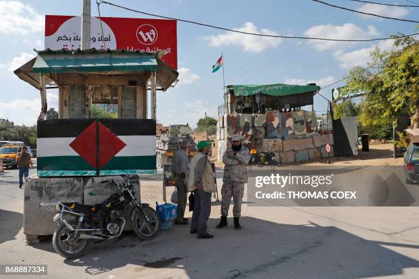 Hamas security men stand guard a at checkpoint sill held by the Islamist group near an area they handed over the control to the Palestinian Authority...