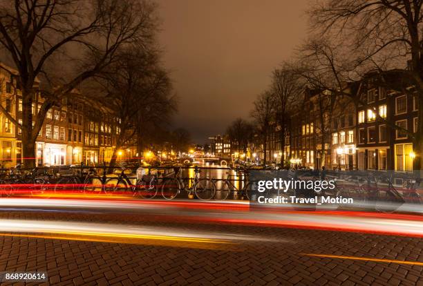 amsterdam-kanalbrücke mit lichtspuren in der nacht - raduno stock-fotos und bilder