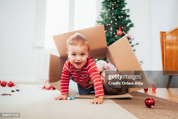 geschwister, schmücken den weihnachtsbaum - baby christmas stock-fotos und bilder