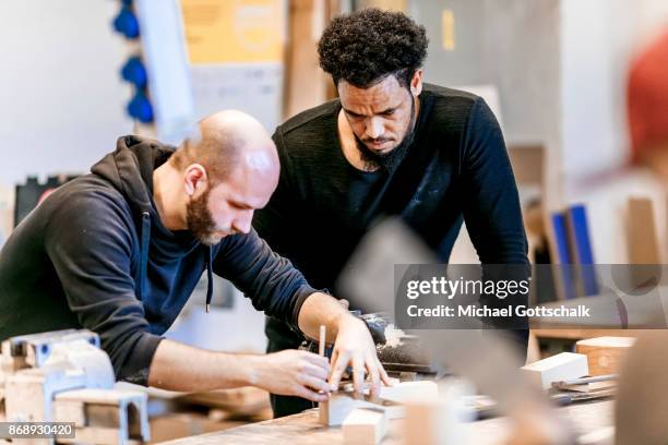 Berlin, Germany A Refugee works next to his trainer at arrivo excercise workshop of Berlin chamber of crafts on October 30, 2017 in Berlin, Germany.