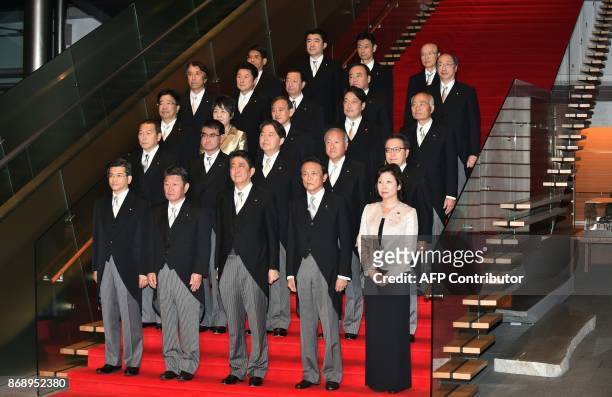 Japan's Prime Minister Shinzo Abe and his cabinet members pose during a photo session following their first cabinet meeting at Abe's official...