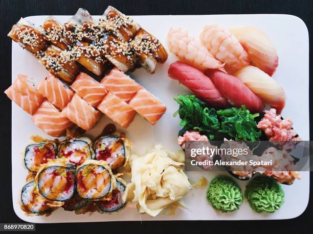 variety of nigiri and roll sushi on a plate, view directly from above - gunkanmaki stock-fotos und bilder