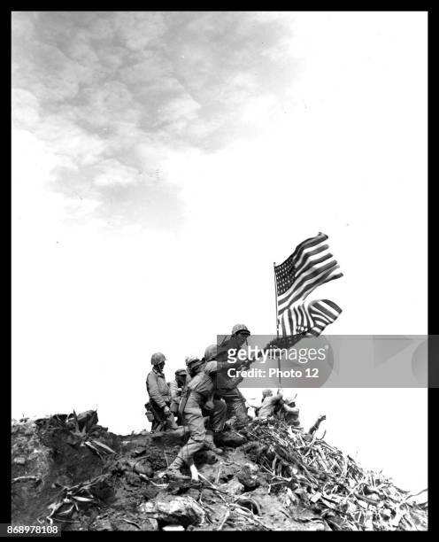 Flag raising on Iwo Jima. Installing large flag on Mt. Suribachi.