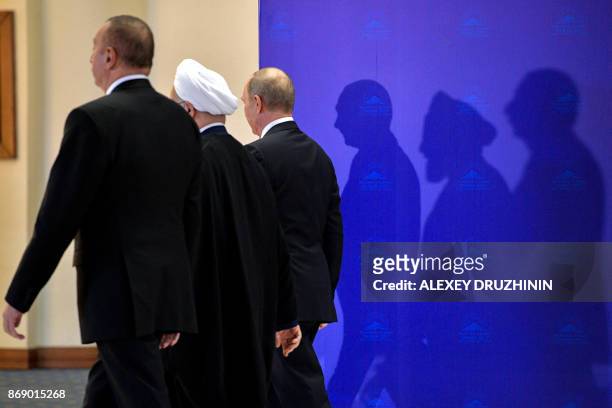 Azerbaijan's President Ilham Aliyev, Iranian President Hassan Rouhani and Russian President Vladimir Putin leave after posing for pictures ahead of...