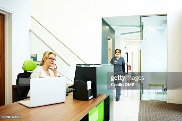 telefoon receptioniste plannen van afspraken in de tandheelkundige kliniek - concierge stockfoto's en -beelden