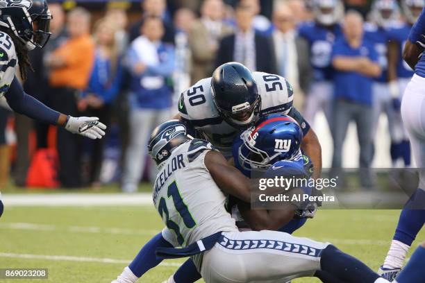 Linebacker K.J. Wright and Safety Kam Chancellor of the Seattle Seahawks make a stop against the New York Giants during their game at MetLife Stadium...